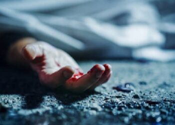 Extreme Close-Up on Victim's Bloody Hand. Still Dead Body Under a Cover and Next to Numbered Markers. Spilled Blood on the Floor Suggests a Violent and Shocking Crime of Passion in Urban City