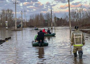 In this photo taken and released by the Administration of the city of Orenburg telegram channel on Friday, April 5, 2024, people use boats while evacuating after a part of a dam burst causing flooding, in Orsk, Russia. (Administration of the city of Orenburg Telegram Channel via AP)