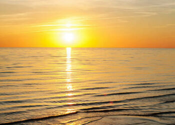 Multicolored summertime sunset on Baltic sea beach. Vertical outdoors image