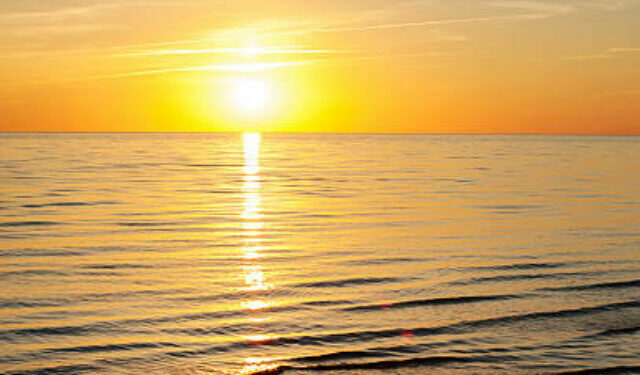 Multicolored summertime sunset on Baltic sea beach. Vertical outdoors image