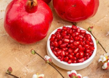 front-view-fresh-red-pomegranates-peeled-with-whole-fruits-brown-background-color-fruit-photo-mellow-juice_140725-141849