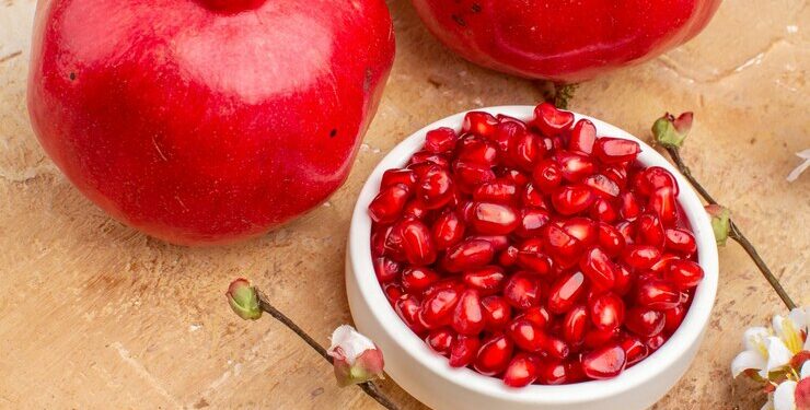 front-view-fresh-red-pomegranates-peeled-with-whole-fruits-brown-background-color-fruit-photo-mellow-juice_140725-141849