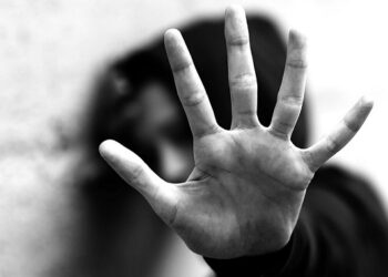 open hand of young girl trying to protect herself from violence with dark dramatic photographic effect