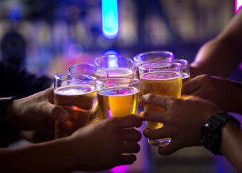 Group of  young people hands toasting and cheering aperitif beers half pint