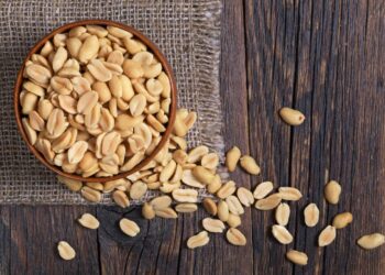 peanuts-in-a-bowl-on-wooden-table-top-down-view