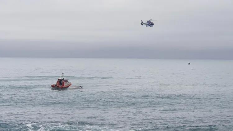 A helicopter and a rescue boat search for survivors off the coast of Kaikoura, New Zealand, Saturday, Sept. 10, 2022. A boat in New Zealand collided with a whale and capsized. (AP Photo)