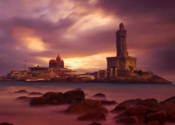 Kanyakumari - Vivekananda Rock Memorial Thiruvalluvar Statue in the evening with a colorful and cloudy sky background.