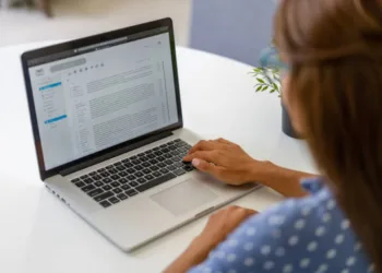 Latin American woman working at home and reading e-mails on her laptop computer - lockdown concepts