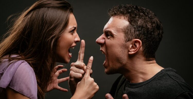 Angry young couple shouting face to face.