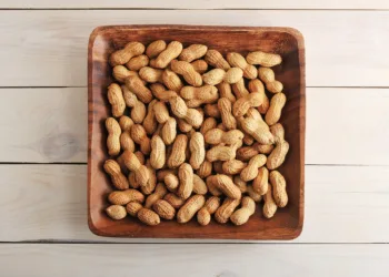 fruits peanut with shell in wooden plate on wooden background - top view