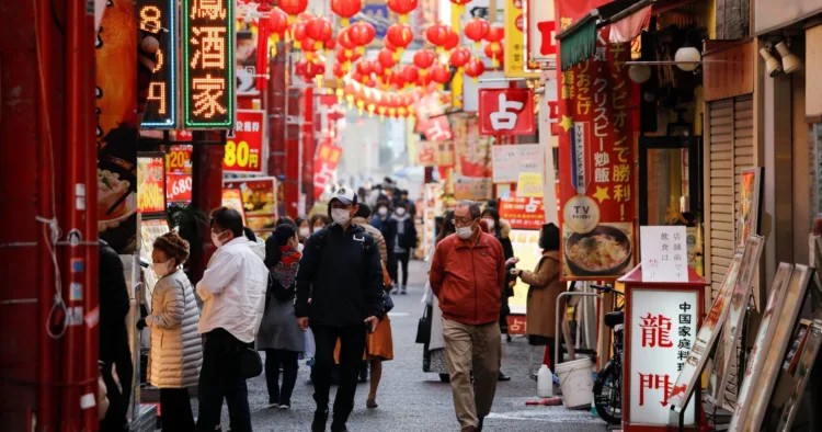 Passersby wearing protective face masks walk on the street at Yokohama's China town, amid the coronavirus disease (COVID-19) outbreak, in Yokohama, south of Tokyo, Japan December 1, 2020.  REUTERS/Issei Kato