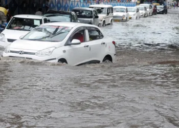 Kolkata: Commuters wade through waterlogged street after heavy rains in Kolkata on Friday, July 30, 2021. (Photo: Kuntal Chakrabarty/ IANS)