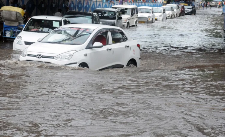 Kolkata: Commuters wade through waterlogged street after heavy rains in Kolkata on Friday, July 30, 2021. (Photo: Kuntal Chakrabarty/ IANS)