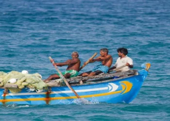 Batticaloa, Sri Lanka - June 24, 2014: Fishermen of Sri Lanka in traditional rowboat. They belong to tamil ethnicity, and are mostly traditional fisherman