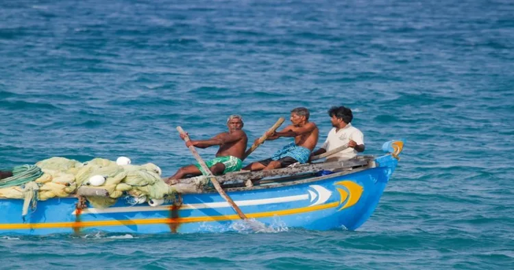 Batticaloa, Sri Lanka - June 24, 2014: Fishermen of Sri Lanka in traditional rowboat. They belong to tamil ethnicity, and are mostly traditional fisherman