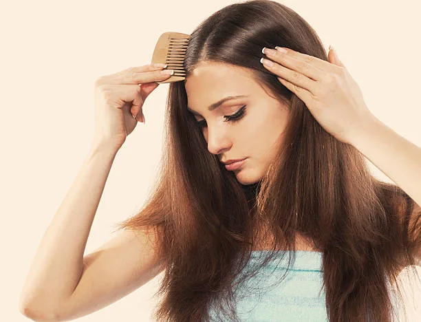 Young brunette lady combing her beautiful long hair. isolated white