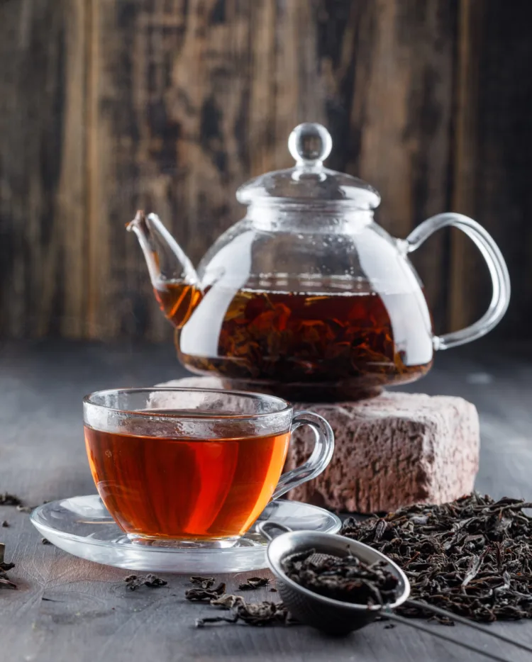 black-tea-teapot-cup-with-dry-tea-brick-side-view-wooden-surface-scaled