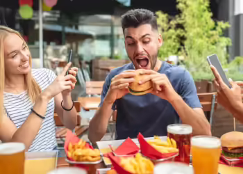 group-friends-having-fun-fast-food-restaurant-women-use-smartphone-shooting-video-photos-social-network-man-eating-junk-food-burgher_164678-379