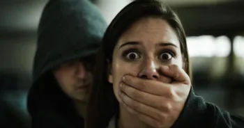 A terrified young woman held captive by a man with his hand over her mouth