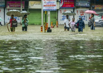 Mumbai: Pedestrians wade through an inundated road amid rains, in Mumbai, Monday, May 26, 2025. (PTI Photo) (PTI05_26_2025_000136B)