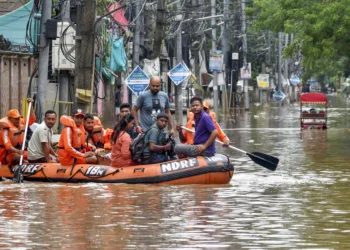 Guwahati: National Disaster Response Force (NDRF) personnel and others move through a waterlogged road aboard a rescue boat to distribute relief material to affected people at an area inundated with rainwater after heavy rainfall, in Guwahati, Assam, Saturday, May 31, 2025. (PTI Photo) (PTI05_31_2025_000104A)