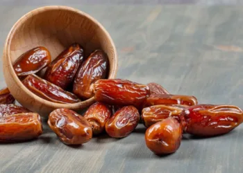 Sweet dates out of wooden bowl on marble background. High quality photo