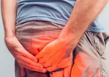 Man-with-hemorrhoids-holding-his-butt-in-pain-in-a-white-background