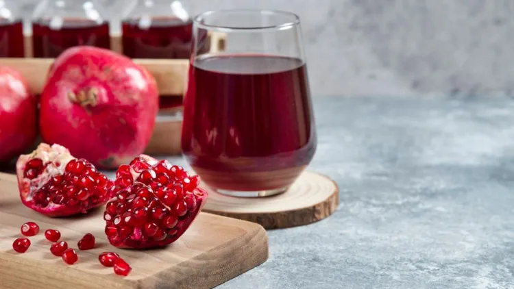 A glass cup of pomegranate juice on a wooden board. High quality photo