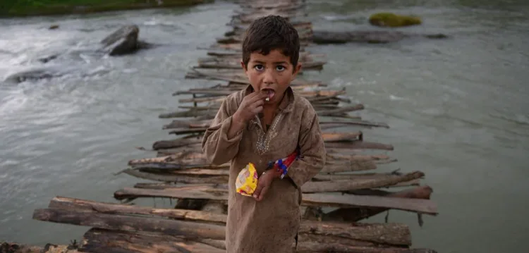 An Afghan refugee boy looks as he crosses a temporary wooden bridge at Jalala refugee camp in district Mardan on April 2, 2014. More than five million Afghan refugees fled war, oppression and poverty, mostly for Pakistan and Iran, in the past three decades. (A Majeed/AFP/Getty Images)
